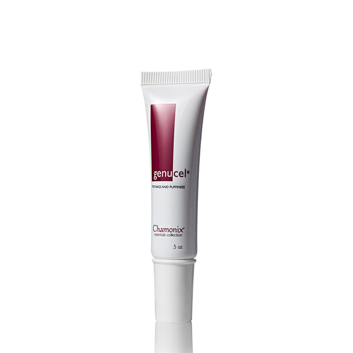 A white tube of Essentials Package by Genucel Skin Care appears on a white background. The label reads "Essentials Package" with "Genucel Skin Care" in smaller letters underneath, highlighting its focus on Eye Bags & Puffiness Therapy. The tube features a maroon design element and the words "Eye Bags and Puffiness." The size is 0.5 oz.