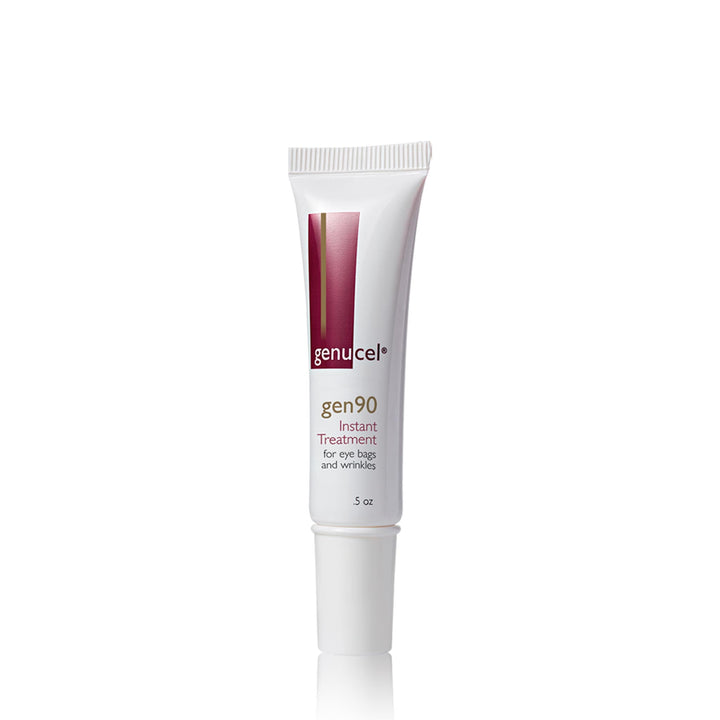 A white tube of skincare product labeled "Essentials Package by Genucel Skin Care," shown against a plain white background, perfect for inclusion in an Eye Bags & Puffiness Therapy Spa Box. The tube is capped and has a maroon design near the top.